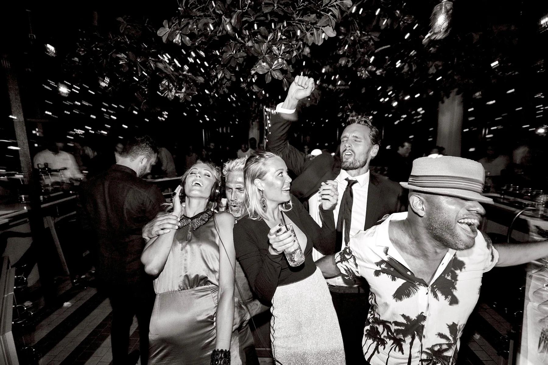 DJ Ale and guests celebrating under confetti in black and white